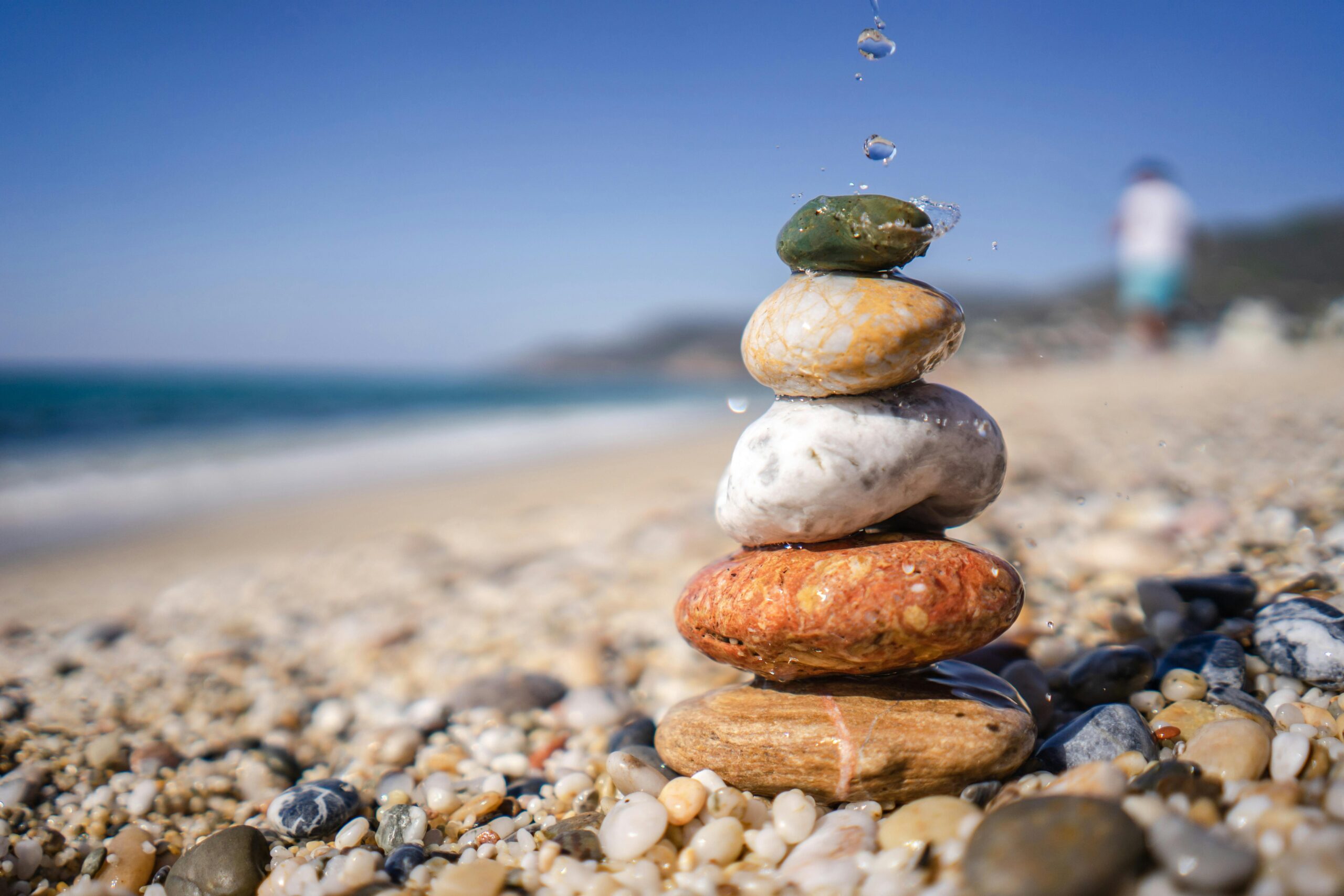 Close-up of stacked stones balancing on a serene pebble beach, symbolizing zen and stability.